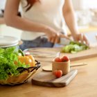 A woman chopping vegetables in a kitchen
