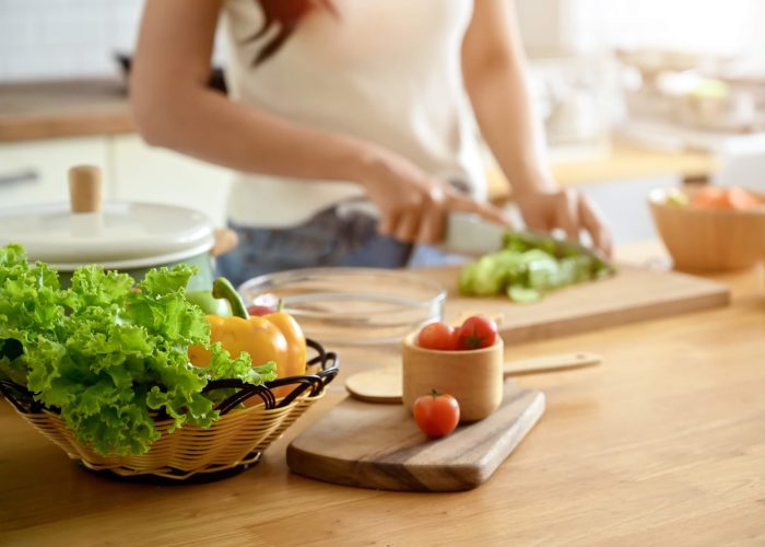 A woman chopping vegetables in a kitchen