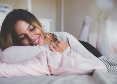 A smiling woman lying on a bed