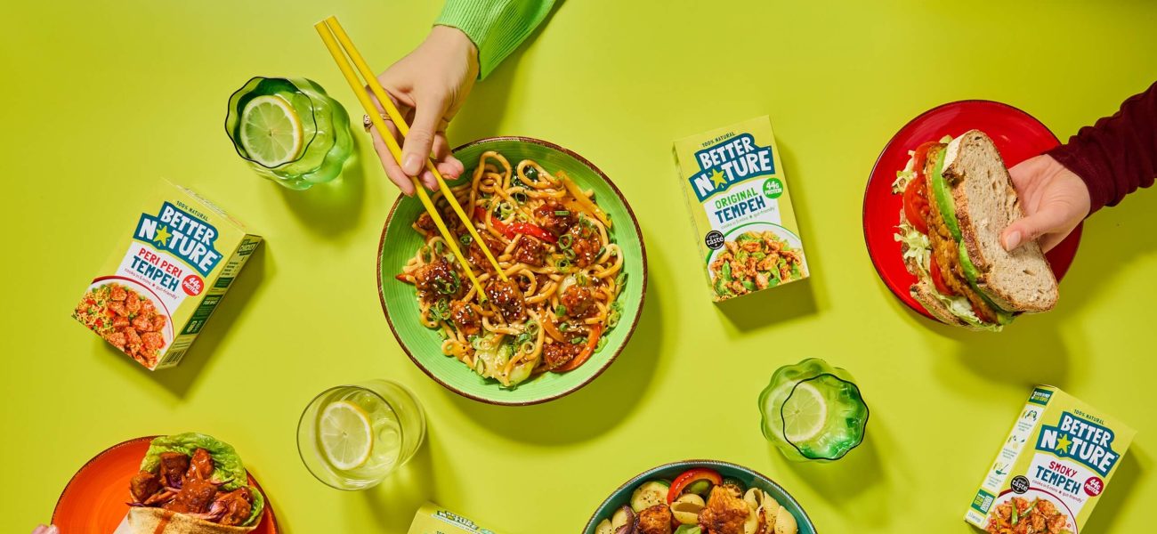 Hands reaching for bowls of Better Nature's tempeh range