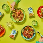 Hands reaching for bowls of Better Nature's tempeh range