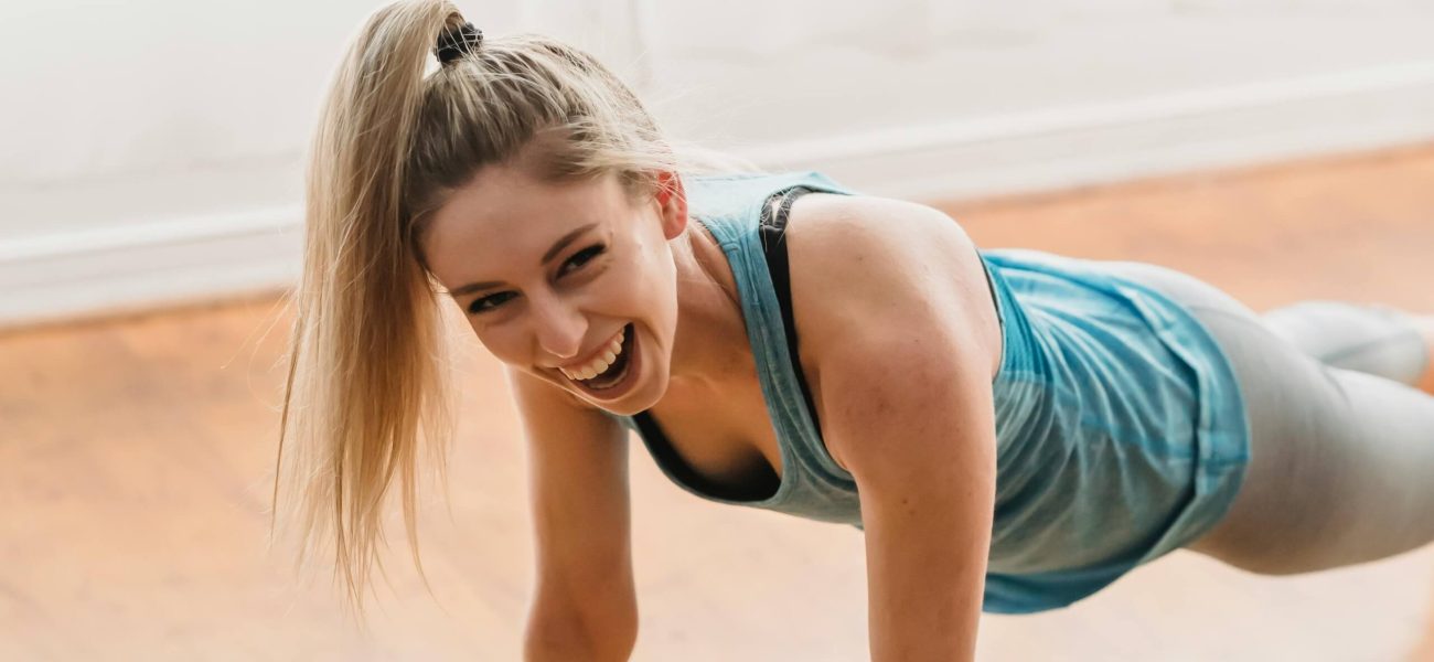 A smiling woman exercising at home