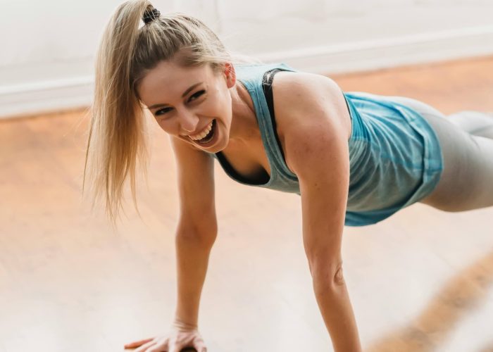 A smiling woman exercising at home