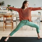 A woman practising a yoga warrior pose at home