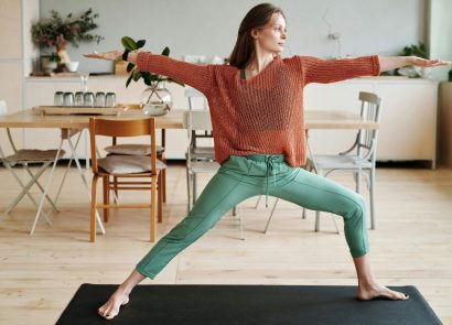 A woman practising a yoga warrior pose at home