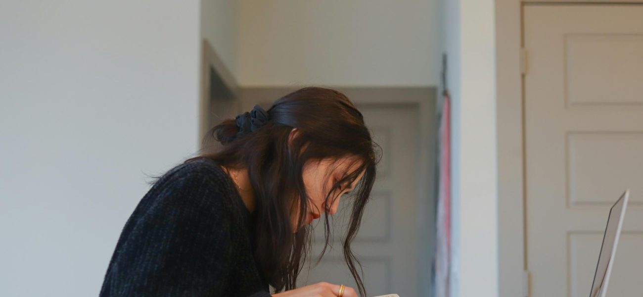 A woman studying on a laptop at home