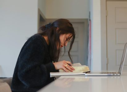 A woman studying on a laptop at home