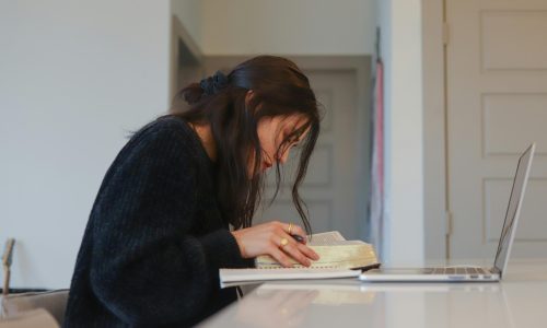 A woman studying on a laptop at home