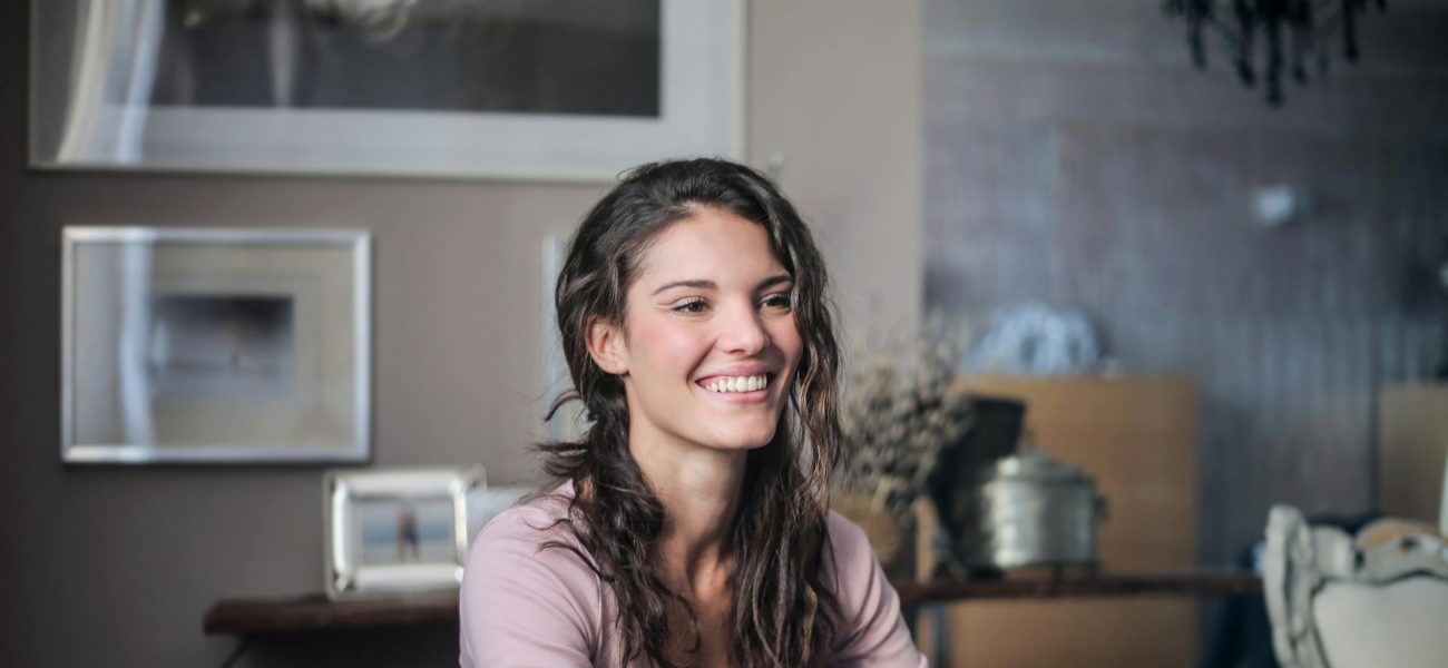 A happy woman sitting in a cosy living room