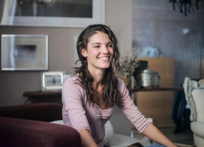 A happy woman sitting in a cosy living room
