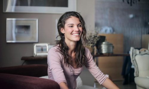 A happy woman sitting in a cosy living room