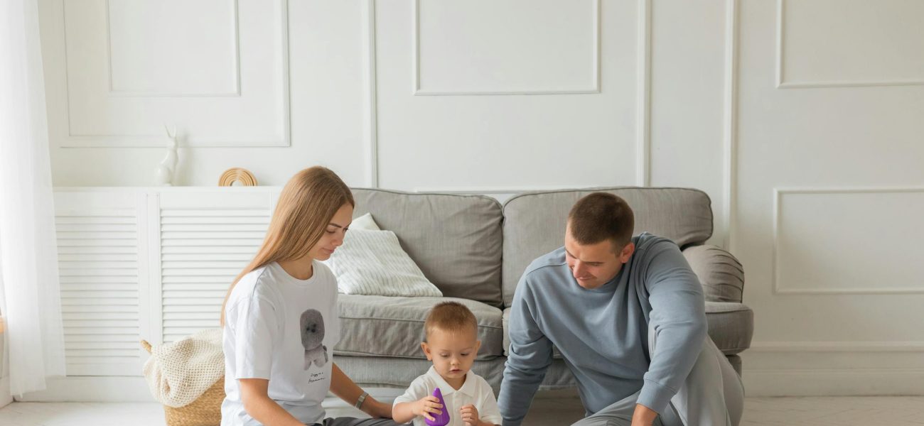 Two parents playing with their baby in a living room