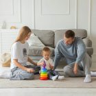 Two parents playing with their baby in a living room