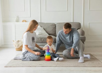 Two parents playing with their baby in a living room