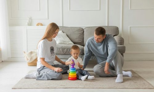 Two parents playing with their baby in a living room