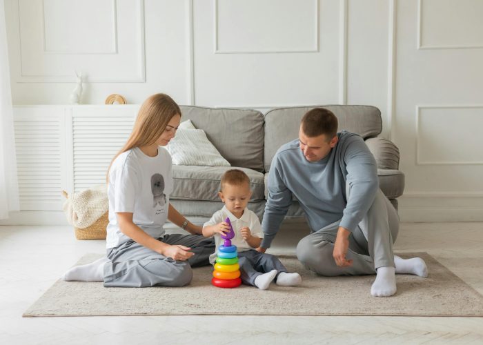 Two parents playing with their baby in a living room