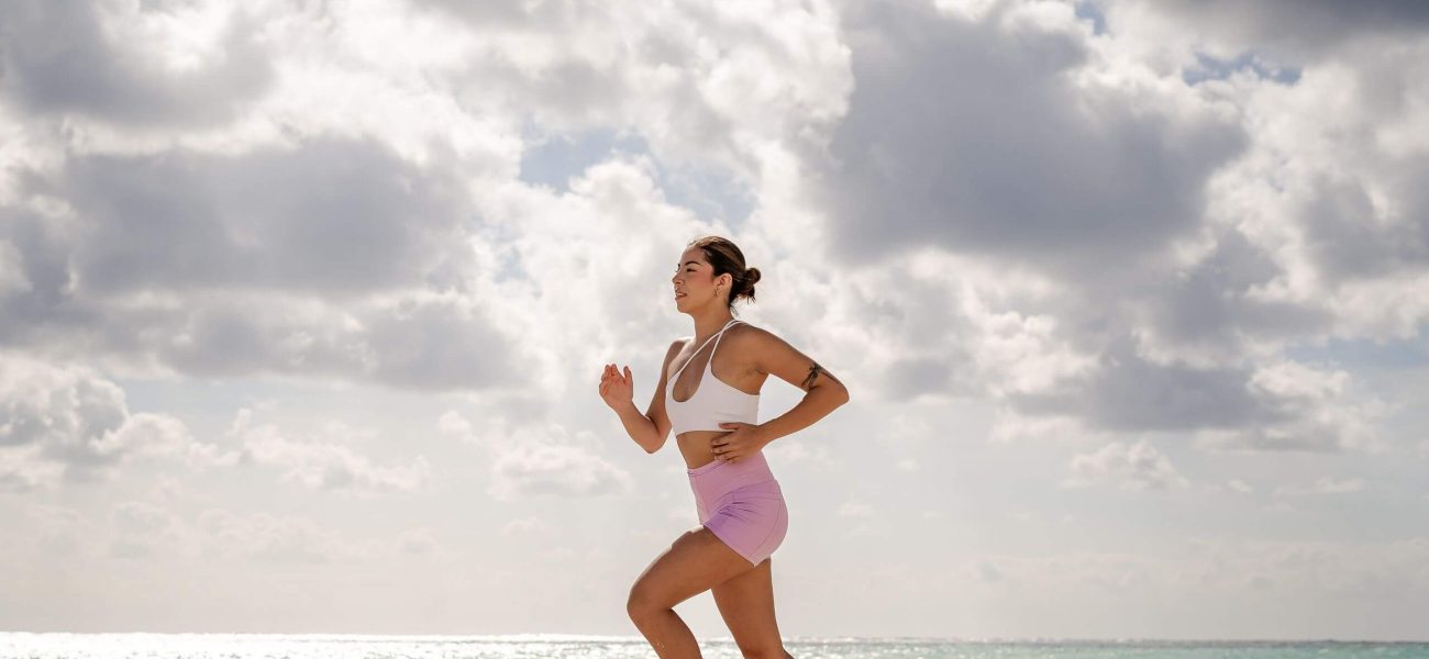 A woman running on the beach on a cloudy day