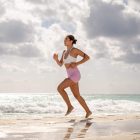 A woman running on the beach on a cloudy day