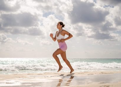 A woman running on the beach on a cloudy day