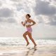 A woman running on the beach on a cloudy day