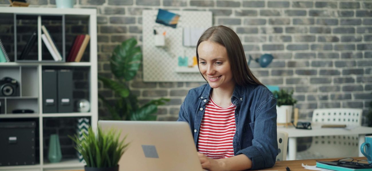 A woman working on a laptop computer in an open-plan office