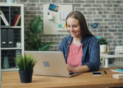 A woman working on a laptop computer in an open-plan office
