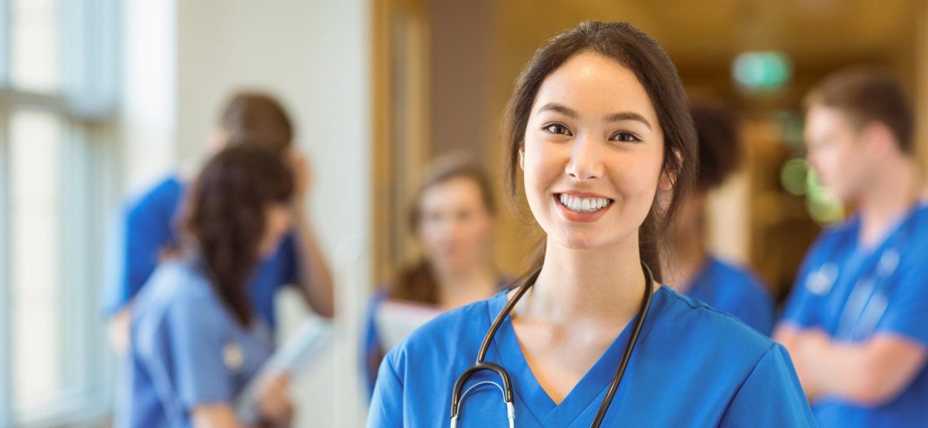 A female doctor with a stethoscope looking at the camera and smiling