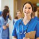 A female doctor with a stethoscope looking at the camera and smiling