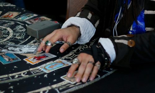 A man laying out tarot cards on a table