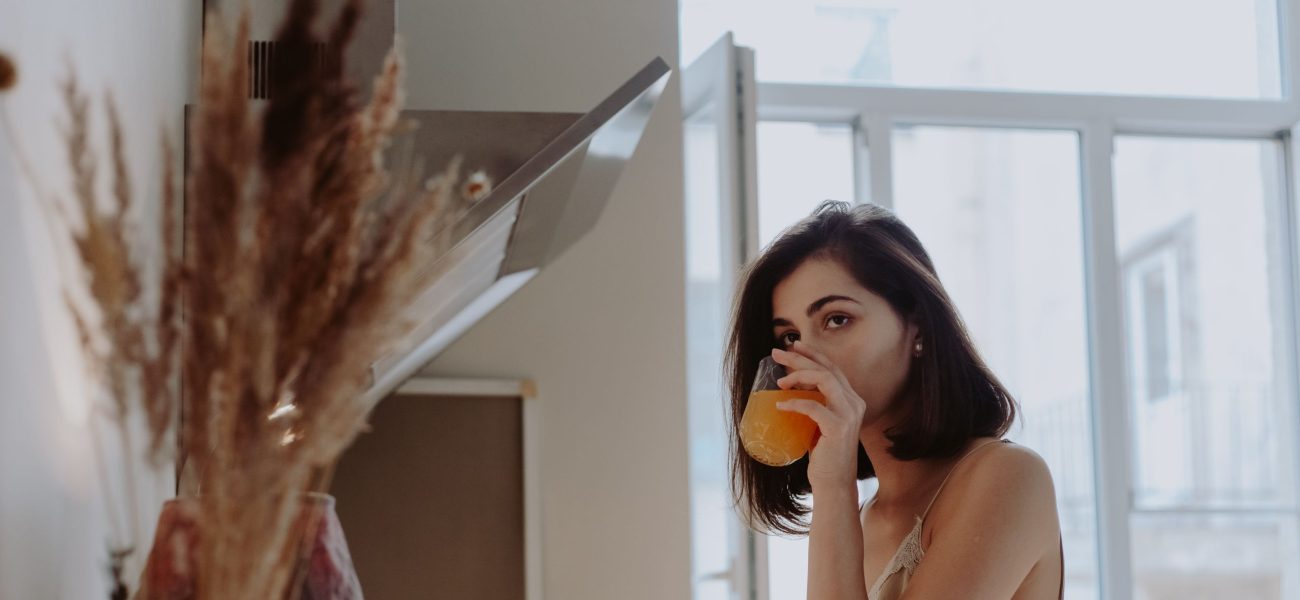 A woman drinking from a glass in the morning