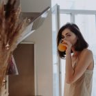 A woman drinking from a glass in the morning