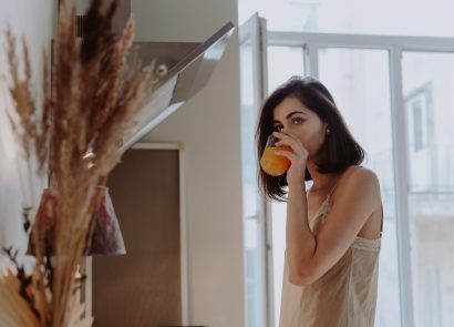 A woman drinking from a glass in the morning