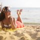 A woman in sunglasses lying on the beach on a summer's day