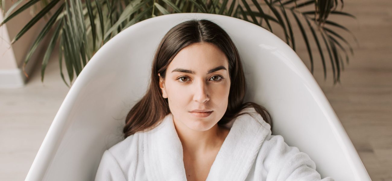 A woman in a spa robe lying in a bathtub