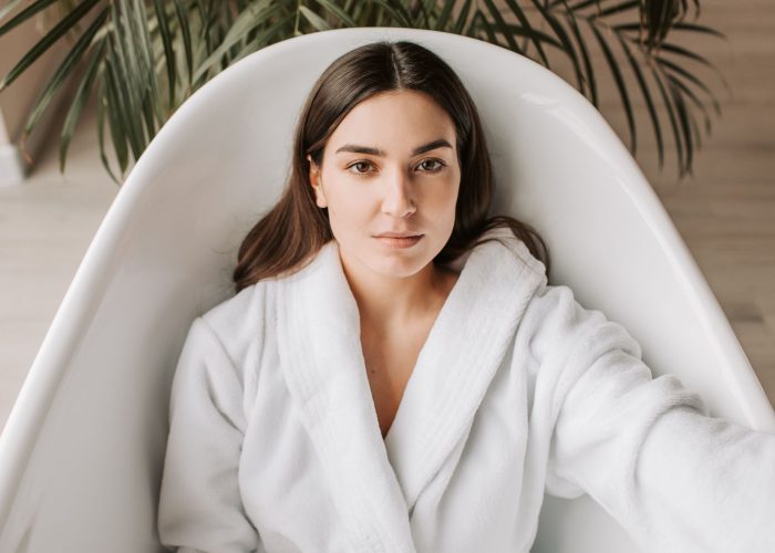 A woman in a spa robe lying in a bathtub