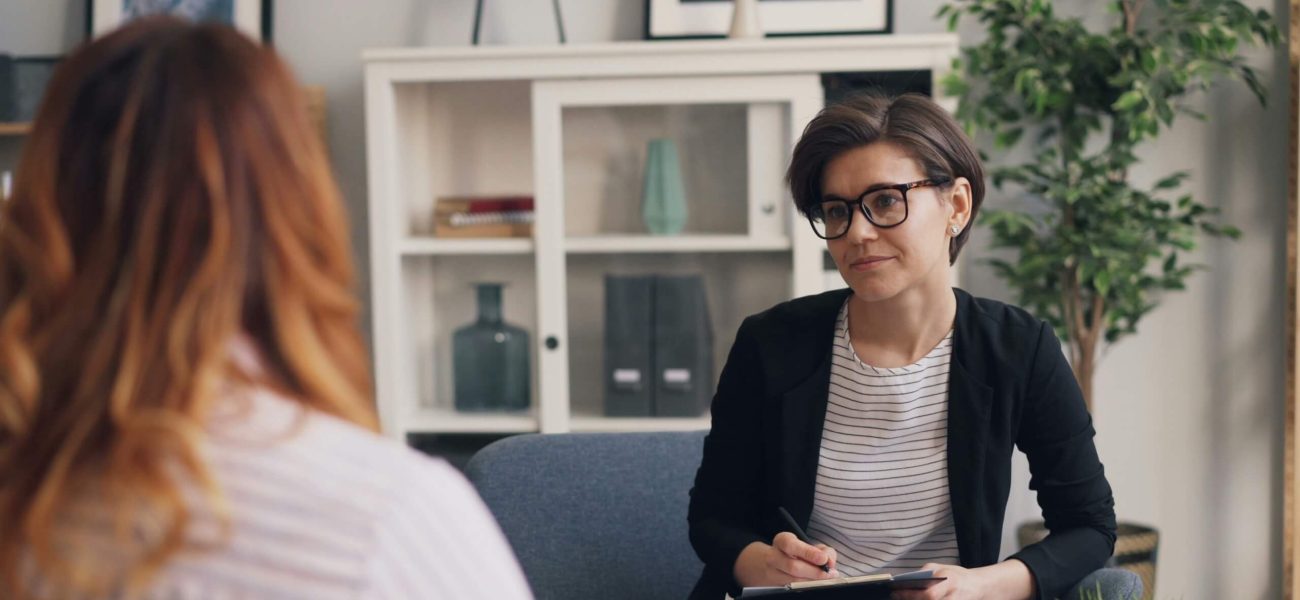 A woman sitting speaking to a female counsellor