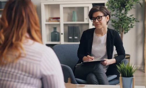 A woman sitting speaking to a female counsellor