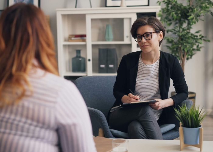 A woman sitting speaking to a female counsellor