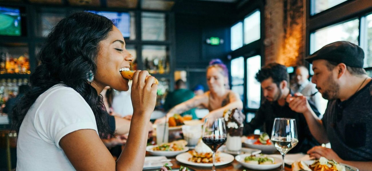 A group of men and women eating together in a restaurant