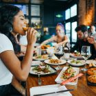 A group of men and women eating together in a restaurant