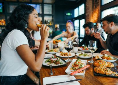 A group of men and women eating together in a restaurant