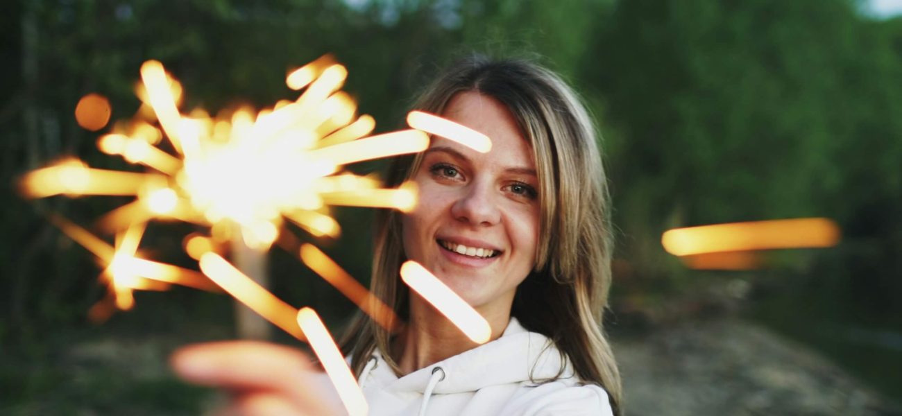 A woman holding a sparkler outdoors