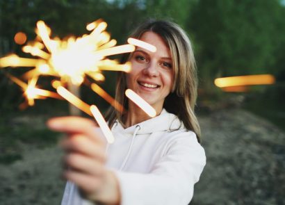 A woman holding a sparkler outdoors