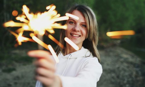 A woman holding a sparkler outdoors