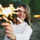 A woman holding a sparkler outdoors