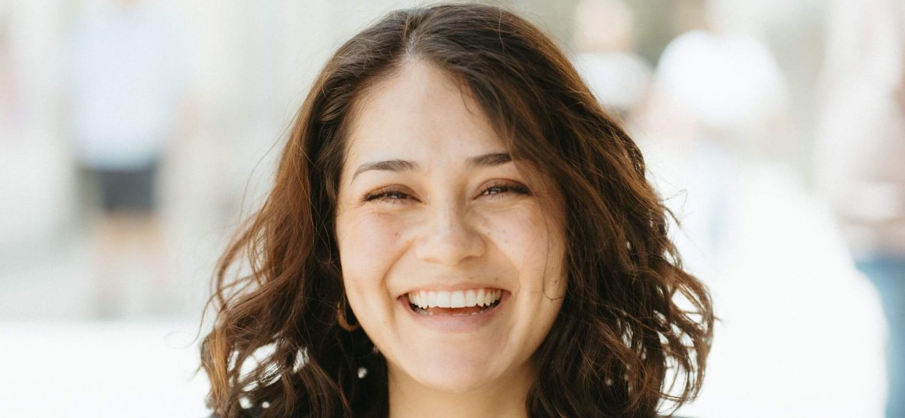 A happy woman with brown hair smiling at the camera