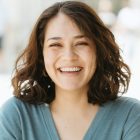 A happy woman with brown hair smiling at the camera