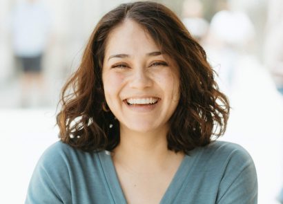 A happy woman with brown hair smiling at the camera